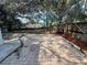 Large backyard with a brick patio, surrounded by mature trees and a wooden fence at 7450 Crooked Lake Cir, Orlando, FL 32818