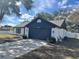 Updated one-story home with white and dark gray exterior, featuring a navy blue garage door at 7450 Crooked Lake Cir, Orlando, FL 32818