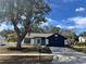 Charming one-story house with a freshly painted exterior, showcasing a teal front door and navy blue garage at 7450 Crooked Lake Cir, Orlando, FL 32818