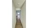 Long hallway with wood-look flooring and a window at the end at 7450 Crooked Lake Cir, Orlando, FL 32818