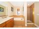Bathroom featuring a tub, walk-in shower with glass door, and a large vanity with ample storage space at 7588 Assembly Ln, Reunion, FL 34747