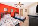 Vibrant bedroom with red accent wall, twin beds with themed bedding, and coordinating furniture at 7588 Assembly Ln, Reunion, FL 34747