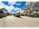 Gated entrance to the community with manicured landscaping and mature trees at 7588 Assembly Ln, Reunion, FL 34747