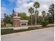 Community entrance with brick sign, mature trees, and lush landscaping at 7588 Assembly Ln, Reunion, FL 34747