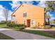 Exterior of a two-story townhome with manicured landscaping, and a sidewalk at 7588 Assembly Ln, Reunion, FL 34747