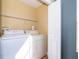 Convenient laundry room equipped with a washer, dryer, and shelving at 7588 Assembly Ln, Reunion, FL 34747
