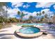 Community pool with an inviting hot tub surrounded by lounge chairs and palm trees at 7588 Assembly Ln, Reunion, FL 34747