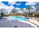 Community pool features palm trees, lounge chairs, and a relaxing atmosphere under a clear blue sky at 7588 Assembly Ln, Reunion, FL 34747