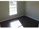 Well-lit bedroom with dark laminate floors and a window at 1972 S Old Mill Dr, Deltona, FL 32725
