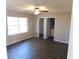 Simple bedroom with dark laminate floors and a view to the bathroom at 1972 S Old Mill Dr, Deltona, FL 32725