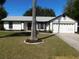 White single-story house with a two-car garage and well-maintained lawn at 1972 S Old Mill Dr, Deltona, FL 32725