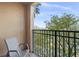 Private balcony with chair, offering treetop views at 12538 Floridays Resort Dr # 411, Orlando, FL 32821