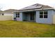Large backyard with grassy area and solar panels on house at 1280 Tupelo Trl, Haines City, FL 33844