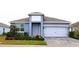 One-story home with gray exterior, white garage door, and landscaped yard at 1280 Tupelo Trl, Haines City, FL 33844