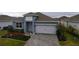 Two-story house with gray exterior, white garage door, and landscaped yard at 1280 Tupelo Trl, Haines City, FL 33844