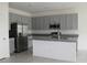 Modern kitchen with gray cabinets, stainless steel appliances, and granite countertop at 1280 Tupelo Trl, Haines City, FL 33844