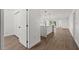 Bright hallway with light wood floors and white walls leading to kitchen at 13380 Sw 60Th Court Rd, Ocala, FL 34473
