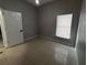 Neutral bedroom featuring tile flooring, window with blinds, and a white door at 143 Glasgow Ct, Davenport, FL 33897