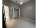 This bedroom features a bi-fold closet, neutral tones and tile floors at 143 Glasgow Ct, Davenport, FL 33897