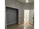 Bedroom featuring a closet with double doors, a white door, and tile flooring at 143 Glasgow Ct, Davenport, FL 33897