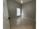 Neutral bedroom featuring tile flooring, window with blinds, and a white door at 143 Glasgow Ct, Davenport, FL 33897
