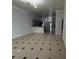 Open-concept living room with tile flooring, stylish lighting fixtures, and a view of the adjacent kitchen at 143 Glasgow Ct, Davenport, FL 33897
