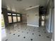 Open living room showcasing tile floors, large windows, neutral paint, and access to other rooms at 143 Glasgow Ct, Davenport, FL 33897