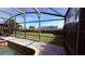 View of backyard and neighboring home through the screen enclosure, showcasing landscaping and neighborhood at 1534 Gants Cir, Kissimmee, FL 34744