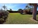 Spacious backyard showcasing green lawn, privacy hedges, and partial view of screened in patio at 1534 Gants Cir, Kissimmee, FL 34744