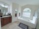 Bathroom featuring a garden tub, double vanity, and walk-in shower at 1534 Gants Cir, Kissimmee, FL 34744