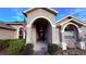 Inviting front entrance with an arched entryway and American flag creating a welcoming approach at 1534 Gants Cir, Kissimmee, FL 34744