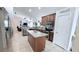 An open kitchen features tile flooring, an island with granite countertops, stainless steel appliances, and wooden cabinetry at 1534 Gants Cir, Kissimmee, FL 34744