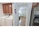 Inviting laundry room with washer, dryer, wood cabinets and a glimpse of a cozy bedroom at 1534 Gants Cir, Kissimmee, FL 34744