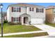 Charming two-story home featuring a well-maintained lawn, attached two-car garage and red window shutters at 1634 Reddish Egret Ct, Davenport, FL 33897