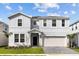 Two-story house with white siding, gray accents, and a two-car garage at 2190 Lelani Cir, Davenport, FL 33897