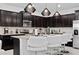 Modern kitchen with dark cabinets, granite counters, and island seating at 2190 Lelani Cir, Davenport, FL 33897