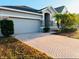 One-story house with gray siding, herringbone driveway, and palm trees at 2304 Cedar Garden Dr, Orlando, FL 32824