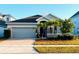 One-story home with gray siding, herringbone driveway, and palm trees at 2304 Cedar Garden Dr, Orlando, FL 32824