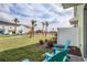 Back yard with two Adirondack chairs, a lawn, and a view of other colorful townhouses at 2929 Caribbean Soul Dr, Kissimmee, FL 34747