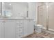 Bathroom featuring double sinks, white cabinetry, and a glass door shower at 2929 Caribbean Soul Dr, Kissimmee, FL 34747