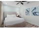 Light-filled bedroom featuring a queen bed, ceiling fan and unique pelican themed artwork at 2929 Caribbean Soul Dr, Kissimmee, FL 34747