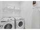 Laundry room featuring a front loading washer and dryer with shelves and storage at 2929 Caribbean Soul Dr, Kissimmee, FL 34747