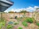 View of the backyard featuring a wooden fence and natural landscaping under a bright, partly cloudy sky at 420 Sunrise Dr, Orlando, FL 32803