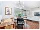 Bright dining room with modern light fixture, wood floors, and sliders to sunroom and living room at 420 Sunrise Dr, Orlando, FL 32803