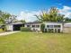 Inviting single-story home featuring a manicured lawn and an eye-catching orange front door at 420 Sunrise Dr, Orlando, FL 32803