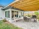 Outdoor living with a paver patio, covered pergola, grill, dining set and well-maintained lawn at 420 Sunrise Dr, Orlando, FL 32803