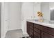 Double vanity bathroom with dark brown cabinets and a large mirror at 5125 Chickadee St, St Cloud, FL 34771