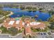 Beautiful aerial view of the community clubhouse overlooking the pool, lake, and surrounding neighborhood at 605 Cantabria Dr, Davenport, FL 33837