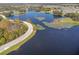 Scenic aerial view of a tranquil lake lined with lush trees and winding roads at 605 Cantabria Dr, Davenport, FL 33837