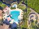 A bird's eye view shows a community pool with pink canopies, yellow umbrellas, and tropical landscaping at 605 Cantabria Dr, Davenport, FL 33837